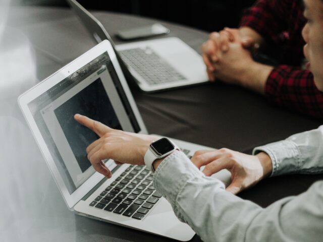 Team members share a laptop screen during a business meeting at Chameleon.