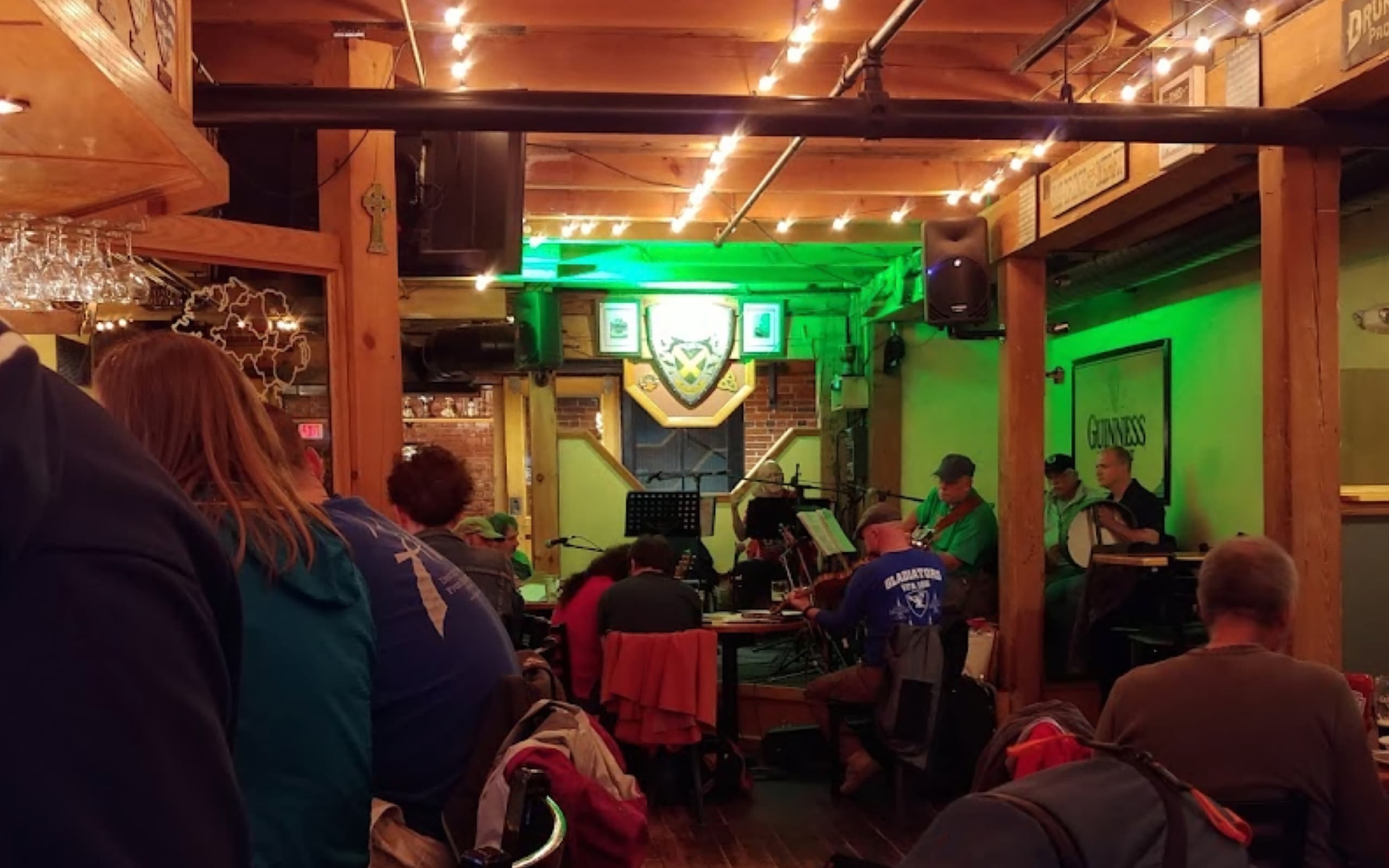 Patrons listen to a jam session while they eat and converse at Cara Irish Pub.