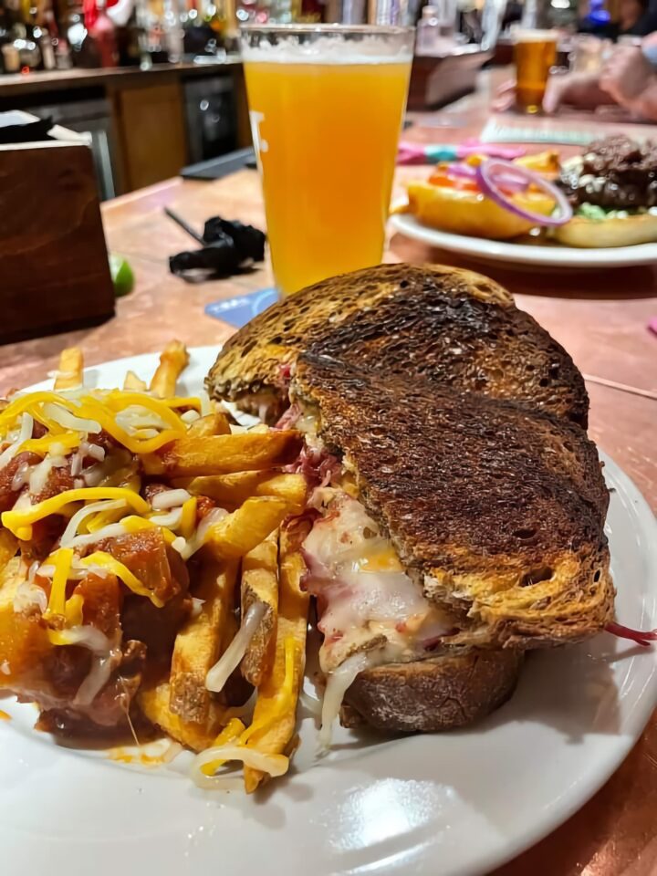 A toasted sandwich, fried, and a beer are served at Cara Irish Pub.