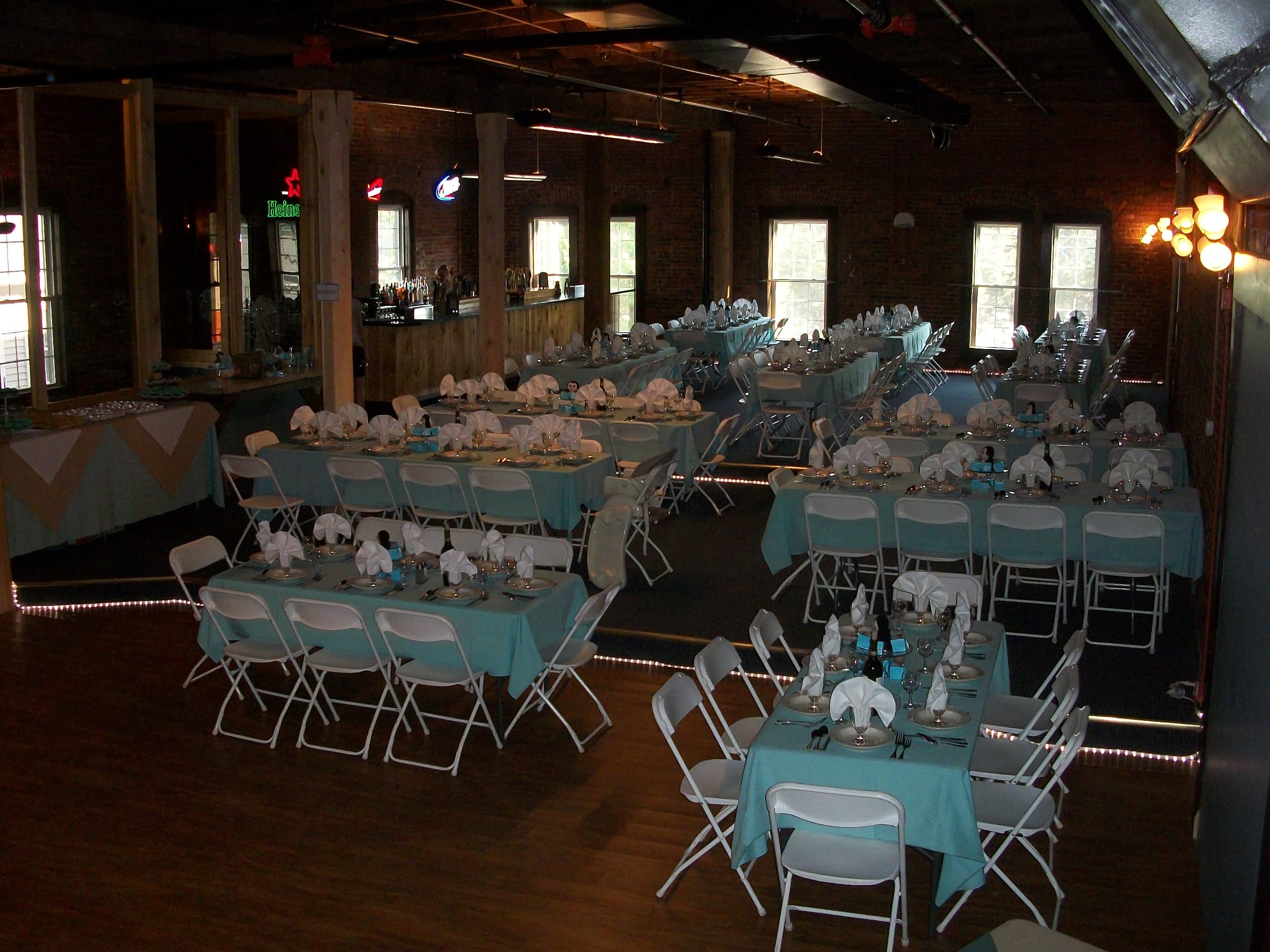 Multiple tables with decorative place settings and chairs away guests for an event at Chameleon.