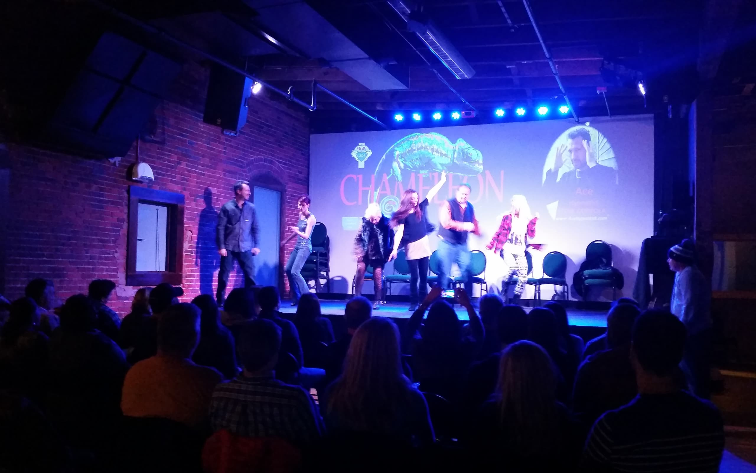 A hypnotist performs at Chameleon with hypnotized audience members on the stage.
